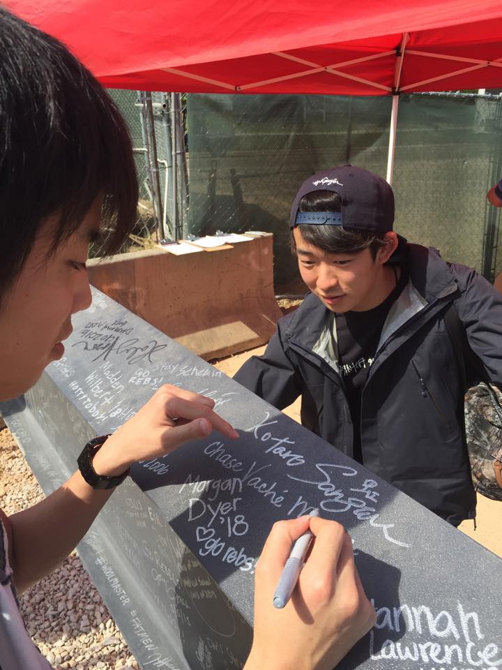 IEP students sign the beam that is part of the new basketball pavilion! 